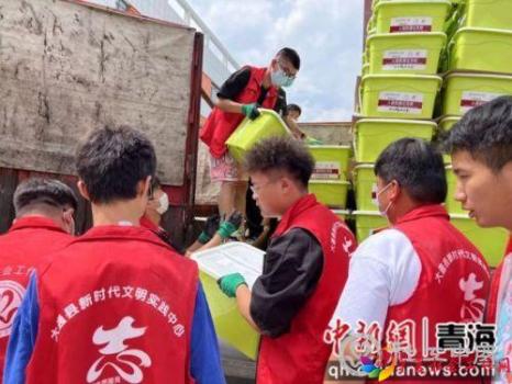 图为志愿者搬运救援物资。