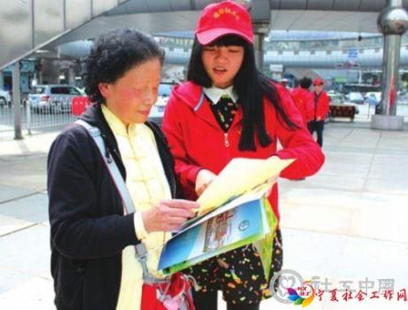 一名社工专业的研究生向市民讲解为老人服务的多种社会工作种类。